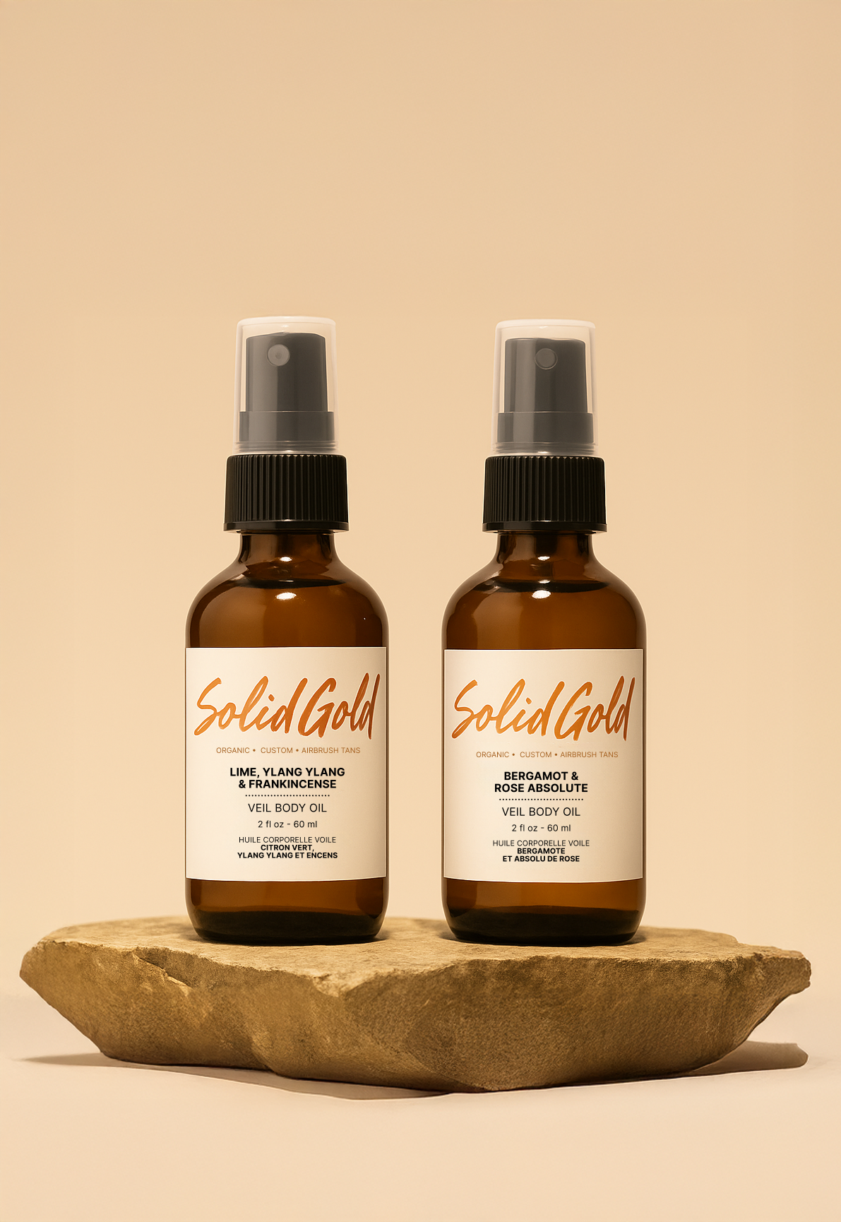 Solid Gold Veil Body Oil bottles on natural stone.